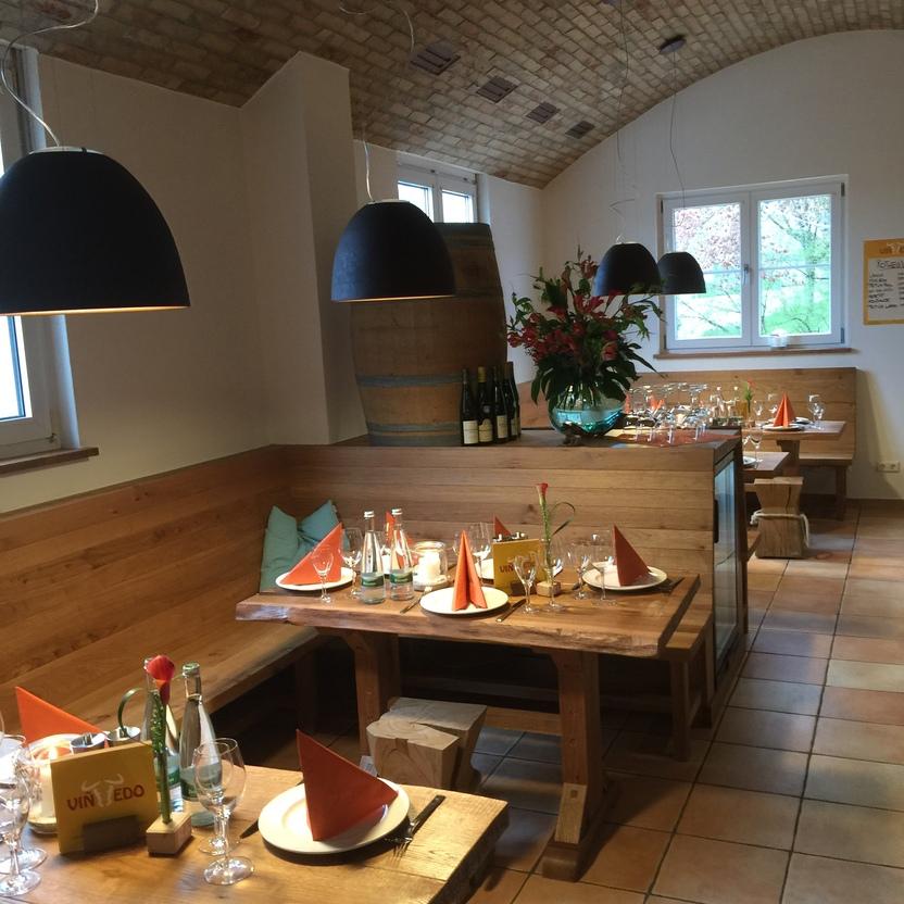 Holztische mit gedecktem Besteck und orangefarbenen Servietten in einem Restaurant.