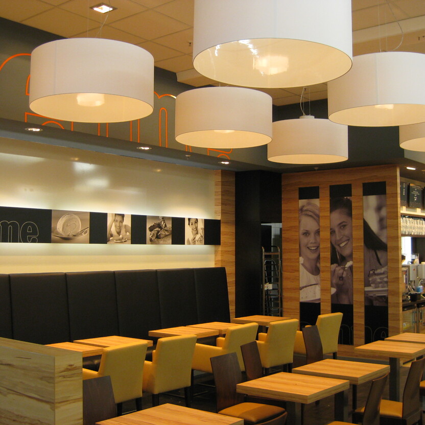 Heller Sitzbereich mit Holz und Polsterung als Teil durchdachten Ladenbaus einer Bäckerei