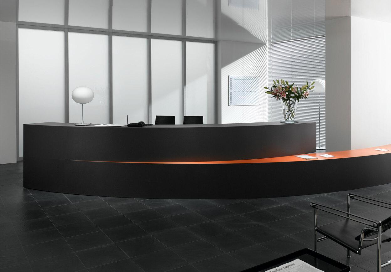 Hotelrezeption mit schwarzem Einrichtungsstil Hotelrezeption mit schwarz lackierter Empfangstheke und orangenem Kontrast